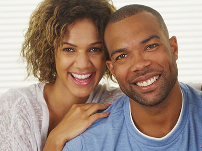 The image depicts a man and a woman posing together with smiles, suggesting a close relationship between them.